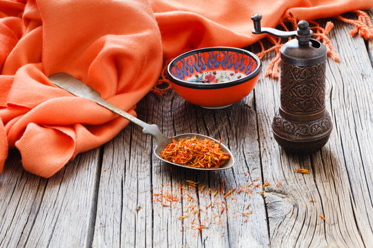 shafran in a spoon on wooden table with silk cloth
