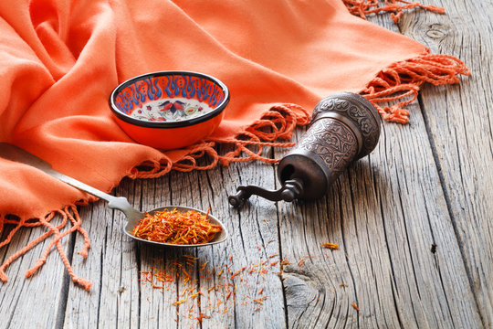 shafran in a spoon on wooden table with silk cloth