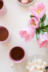 Spring background. Sweets and tea on a table with pink tulips. Still life with fresh bouquet of tulips. concept of a ladies' tea drinking. morning tea.