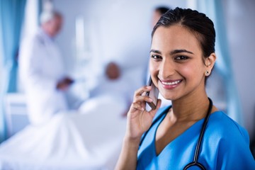 Smiling female doctor talking on a mobile phone