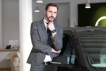 Single man chooses a car in the showroom