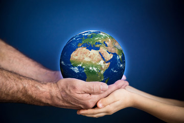 Senior man and child holding Earth planet in hands