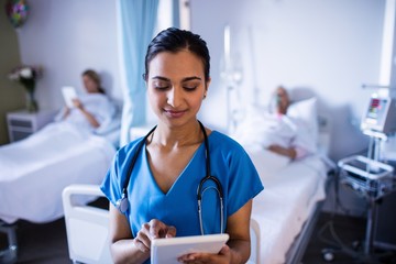 Beautiful female doctor using digital tablet in the ward