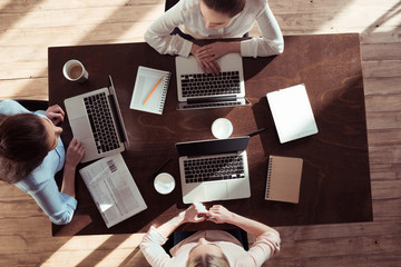 overhead view of businesswomen working at table on new business project