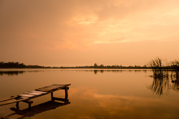 wooden bridge at the lake on sunset