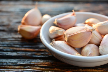 piece of garlic for healthy and cooking on white plate and put on wooden table.