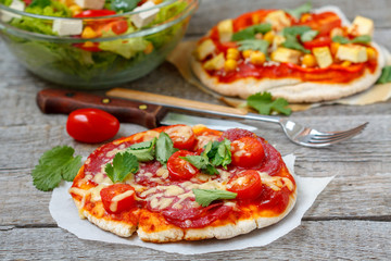 Homemade mini pizzas (meat and vegan) with vegetable salad.