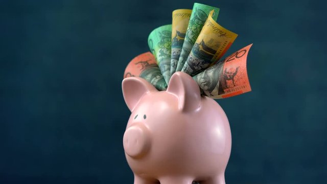 Australian currency with pink piggy bank