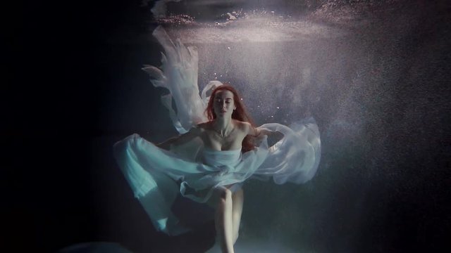 young woman swimming under the water