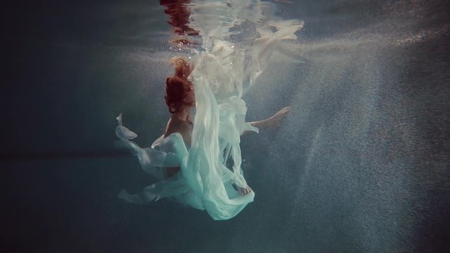 young woman swimming under the water