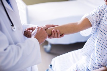 Fototapeta premium Mid section of male doctor examining female patient
