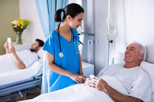 Female doctor interacting with male senior patient