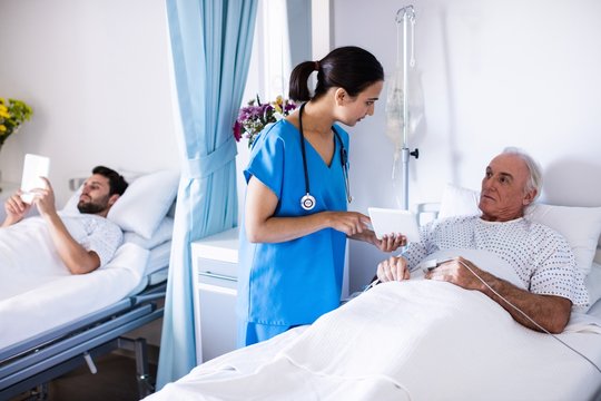 Female doctor discussing with male senior patient 