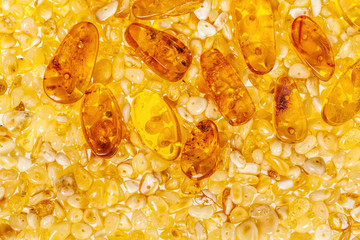 Yellow amber stones closeup lie on a flat surface.