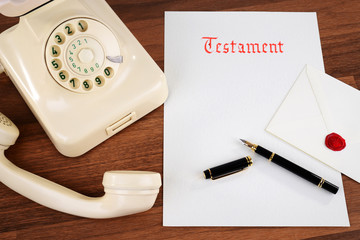 Testament mit Kuvert, altem Telefon und Füller