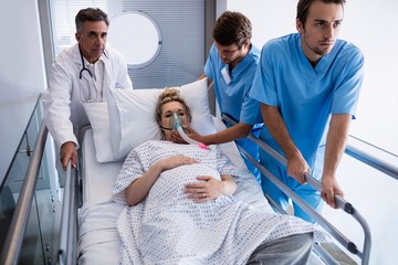 Team of doctors taking pregnant woman to operation theatre