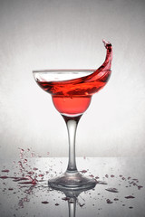 Splash in glass of a pink alcoholic cocktail drink