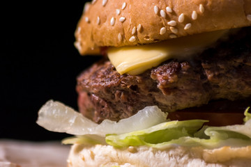 Close-up of a burger. Fresh lettuce and grilled meat. Melted cheddar and juicy beef.