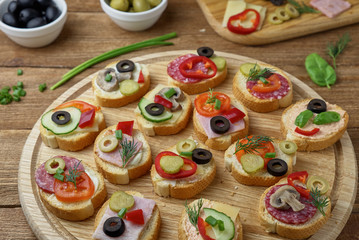 Delicious Crostini with different toppings on wooden background