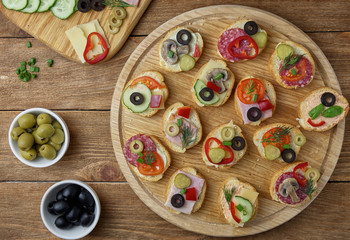 Delicious Crostini with different toppings on wooden background