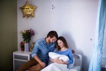 Couple with their newborn baby in the ward