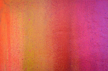 Part of a stone wall with colorful paint marks, paint texture, paint sprayed wall with colorful stains and flowing paint
