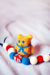 handmade teddy bear and The British flag of fluffy woolen balls is strung like beads on a string