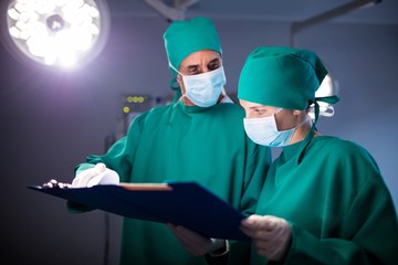Surgeon checking over a medical report of patient