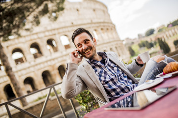 Young man sitting and having a cup of coffee in Rome, Italy