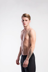 Young handsome hipster shirtless fitness man. Studio shot.