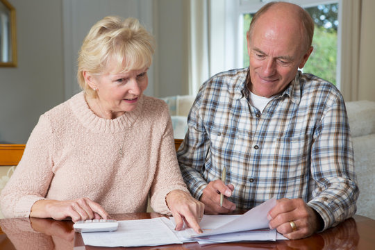 Happy Senior Couple Reviewing Domestic Finances Together