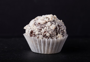 One chocolate candy on a slate background