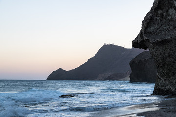 Fototapeta na wymiar sunset over a rocky beach by the sea
