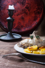Prerared rabbit meat with potato on a rustic style background. Selective focus