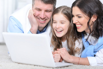 Family with daughter using laptop
