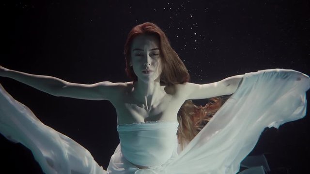 young woman swimming under the water