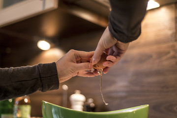 hands cracking an egg into bowl to make fresh waffles