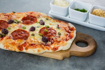 Italian pizza served with ingredients on a chopping board
