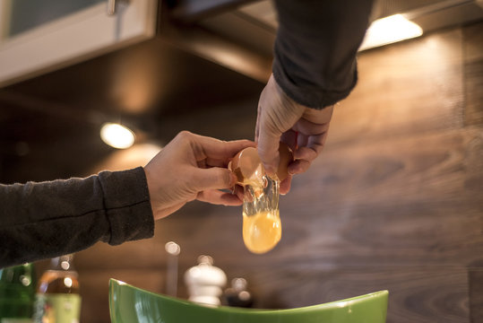 Hands Cracking An Egg Into Bowl To Make Fresh Waffles