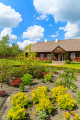 Fototapeta na wymiar Old traditional manor house and beautiful garden in Tokarnia village on sunny spring day, Poland