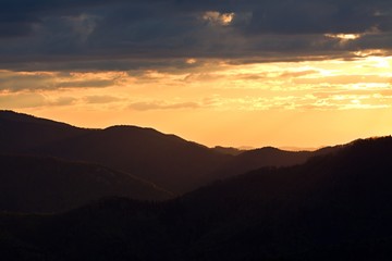 Sunrise in Slovakia. Orange sun sky over dark mountains. Romantic atmosphere. Fog hills at sunset.