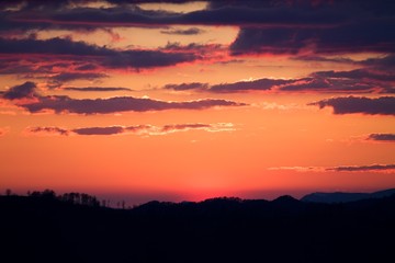 Sunrise in Slovakia. Orange sun sky over dark mountains. Romantic atmosphere. Fog hills at sunset.