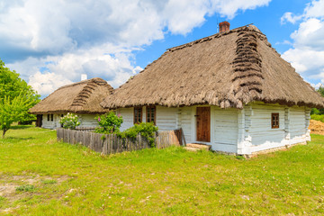Fototapeta na wymiar Old traditional houses with straw roof in Tokarnia village on sunny spring day, Poland