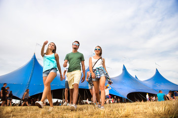 Teenagers at summer music festival in front of big blue tent