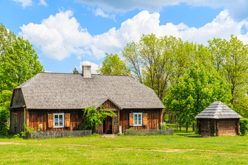 Obraz premium Old traditional wooden house in Tokarnia village on sunny spring day, Poland