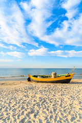 Fototapeta na wymiar Colorful fishing boat on sandy Debki beach during sunny summer day, Baltic Sea, Poland