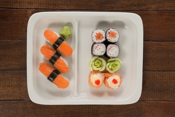 Uramaki and nigiri sushi served in white plate