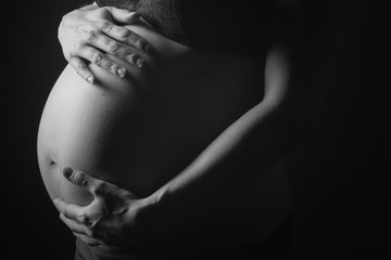 Frau ist schwanger und streichelt ihren Babybauch