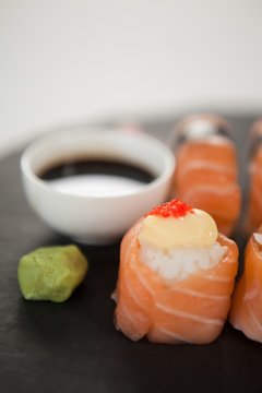 Nigiri sushi served on black stone slate with soy sauce