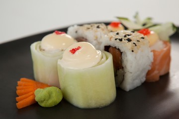Uramaki and nigiri sushi served in black plate 